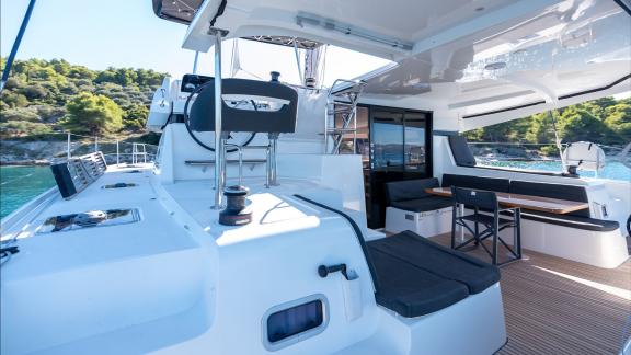 In Kastela bareboat catamaran charter Find Us with wooden deck flooring and elegant texture for stylish cruise.