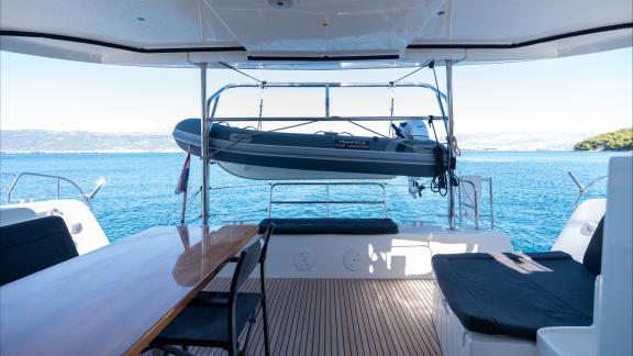 In Kastela bareboat catamaran charter Find Us with aft dining table, service setup and sea view for relaxing cruise.