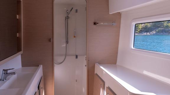 In Kastela bareboat catamaran charter Find Us bathroom with shower, sink and compact layout for practical use.