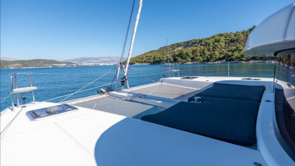 In Kastela bareboat catamaran charter Find Us with net area and cushions perfect for sunbathing and relaxing cruise.