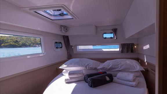 In Kastela bareboat catamaran charter Find Us guest cabin with bed, windows and natural light for comfortable stay.