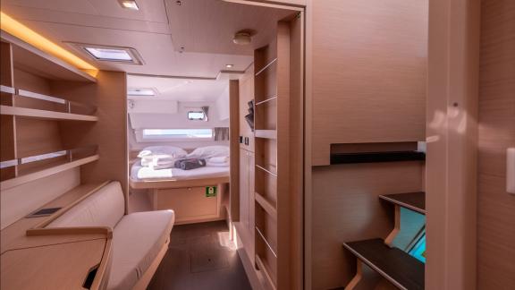 In Kastela bareboat catamaran charter Find Us cabin with bed, storage units and compact layout for comfortable stay.