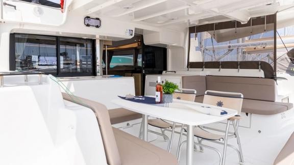 Among Rhodes catamaran charter options Escape 46 shows cockpit with dining table and seating area.