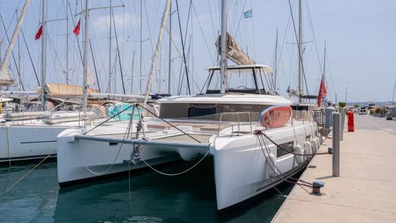 Among Rhodes catamaran charter options Escape 46 shows front view moored in marina.