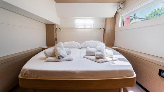 Among Rhodes catamaran charter options Escape 46 shows cabin with large bed and bright interior.