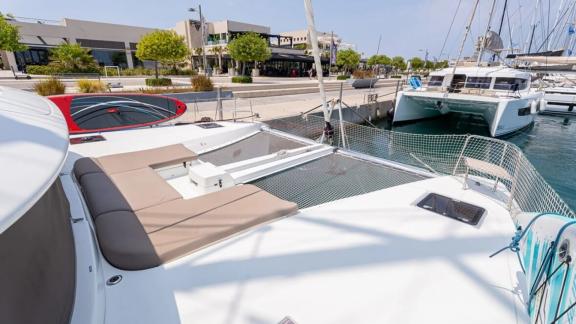 Among Rhodes catamaran charter options Escape 46 shows front deck with net lounge and seating area.