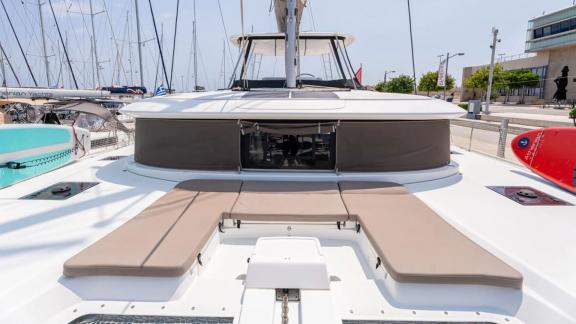 Among Rhodes catamaran charter options Escape 46 shows front deck with sunbed and relaxing space.