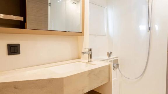 Among Rhodes catamaran charter options Escape 46 shows bathroom with sink and shower for comfortable use.