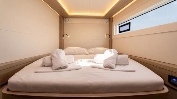 Among Rhodes catamaran charter options Escape 46 shows cabin with comfortable bed and warm ambient lighting.