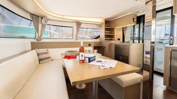 Among Rhodes catamaran charter options Escape 46 shows interior with dining area and kitchen space.