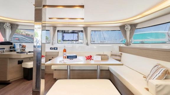 Among Rhodes catamaran charter options Escape 46 shows interior with dining table and spacious seating area.