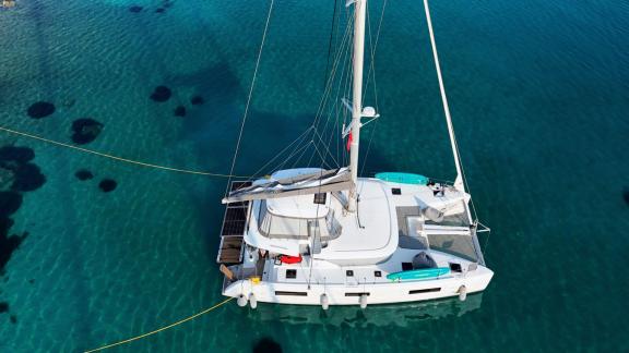 Zalina is anchored near Athens in turquoise waters, with paddle boards on deck.