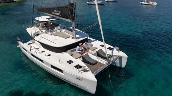 Aranel is anchored off Lefkada, foredeck lounge in view. She offers 6 cabins and accommodates 10 guests.