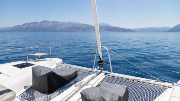 The foredeck of Aranel catamaran in Lefkada features netted areas and cushioned seating.