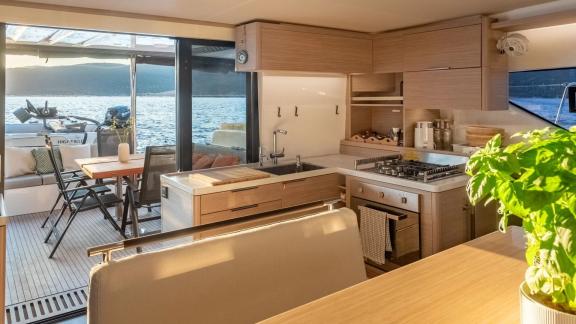 The galley of Aranel catamaran in Lefkada includes a stove, oven, wide counter and door to the aft deck.