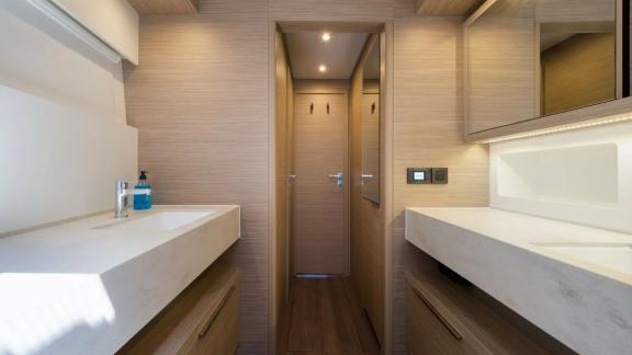 Ванная оснащена двумя мраморными раковинами, зеркалами и деревянными шкафами.