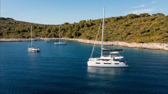 Катамаран Catwalk Lagoon 51 стоит в спокойной бухте недалеко от Кастелы рядом с другими яхтами.