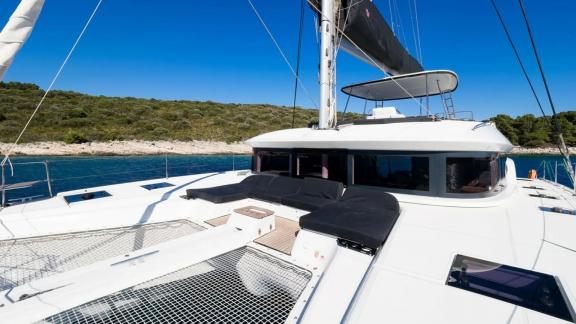 На носу катамарана Lagoon 51 Catwalk установлены мягкие лежаки и сетка для отдыха у Кастелы.