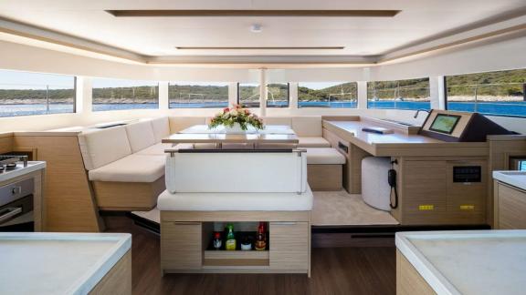 В салоне катамарана — панорамные окна, обеденный стол и оборудованная кухня для комфортного отдыха.