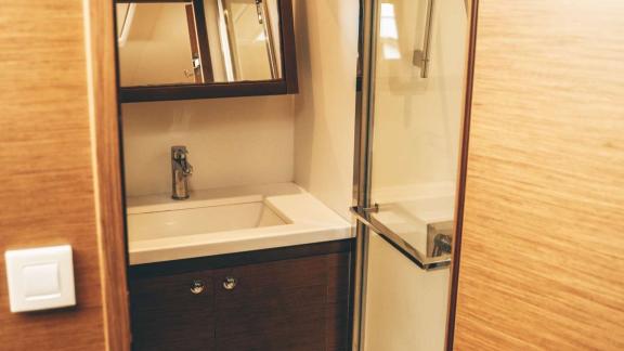 Akana’s bathroom features a sink, mirrored cabinet, and glass shower enclosure.