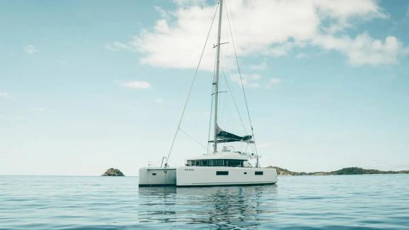Akana rests peacefully in calm sea with small islands in the background.