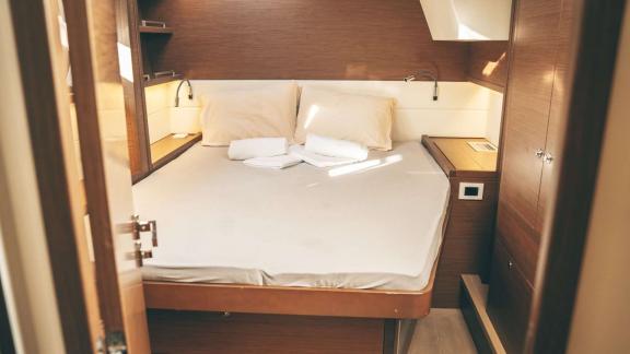 Akana’s cabin features a cozy bed, folded towels and warm wooden furnishings.