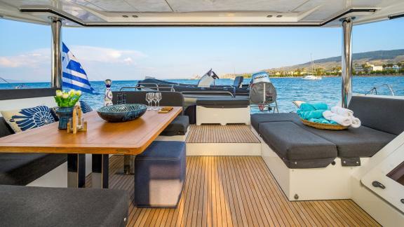 Largo Winch features a comfortable aft deck lounge, perfect for relaxing during a catamaran charter near Mykonos.