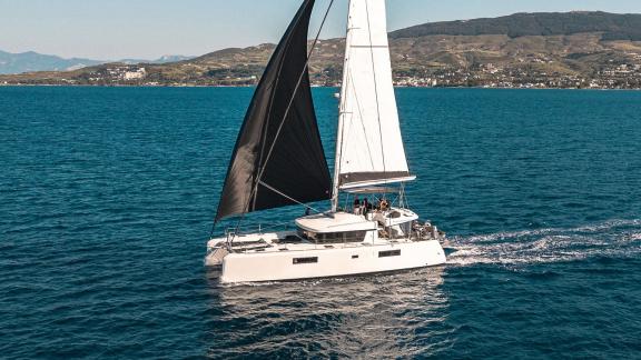 Largo Winch sails off the coast of Mykonos, offering an unforgettable catamaran charter experience on the Aegean Sea.