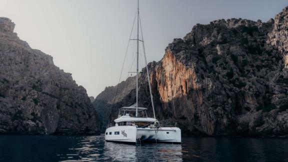 Almosta Road Catamaran Anchored Near Rocky Cliffs in Athens