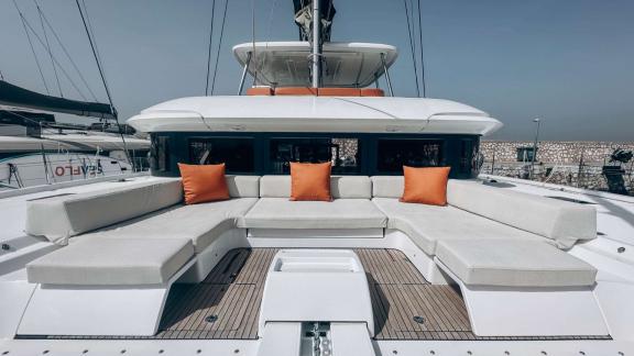 Wide cushioned seating with orange pillows on Aurelia’s front deck.