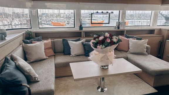 In Aurelia’s lounge, a cozy sofa with elegant cushions surrounds a table adorned with fresh flowers.