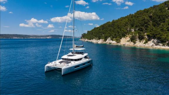 Der Lagoon 55 Champagne Please Katamaran liegt in einer Bucht nahe Kaštela vor Anker und bietet Erholung auf See.