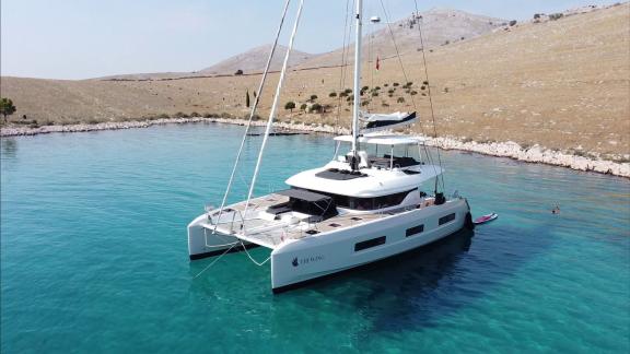 The Lagoon 55 Tri Wing is anchored in crystal-clear waters of a peaceful bay near Kastela's rocky hills.
