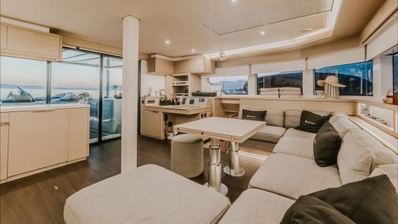 Inside Tri Wing’s Lagoon 55, a spacious lounge with dining table and modern kitchen offers comfort and style.