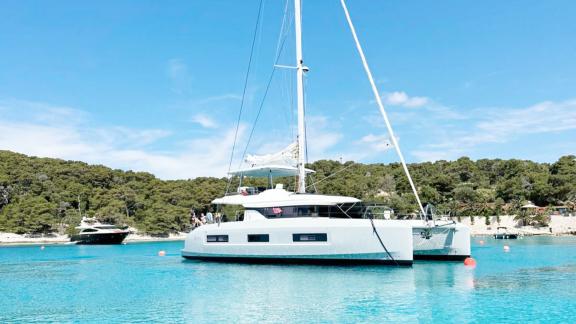 Tri Wing catamaran anchored in turquoise Kastela bay