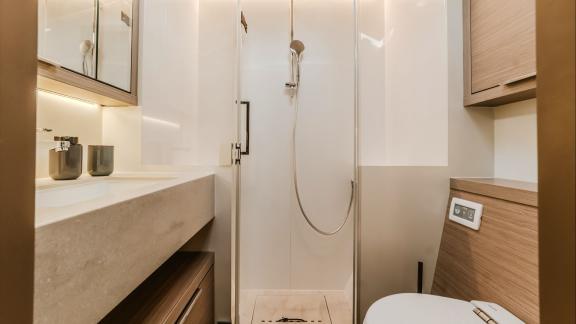 Among catamaran rental options Triwing Ossus bathroom with shower and sink offers a clean and functional onboard space.