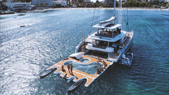 Large floating platform behind the catamaran invites guests to enjoy the sea and fun water activities.