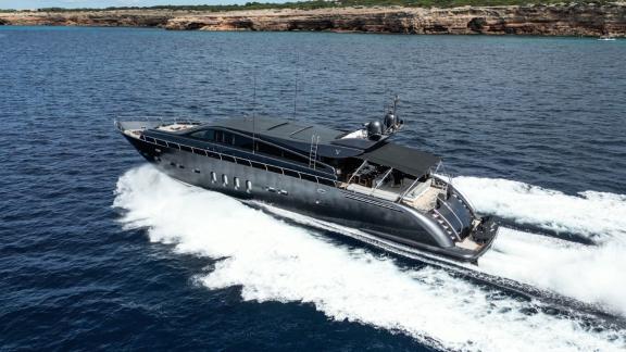 Motor yacht Dark Knight showcases its engine power as it swiftly moves across the open sea.