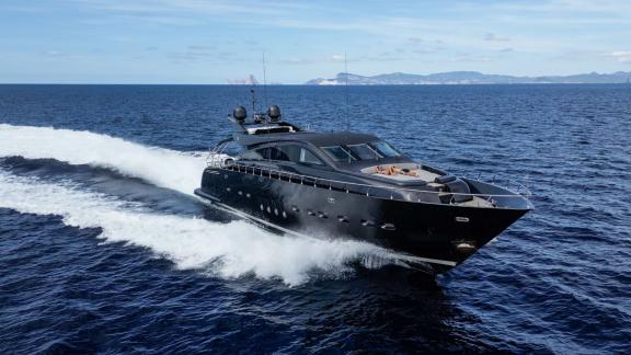 Die Motoryacht Dark Knight zeigt ihre Kraft und Eleganz, während sie mit hoher Geschwindigkeit über das blaue Wasser fäh