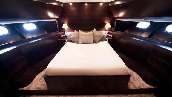 Among Cannes yacht charter options Cristal 1 motor yacht shows cabin with large bed and ambient lighting.