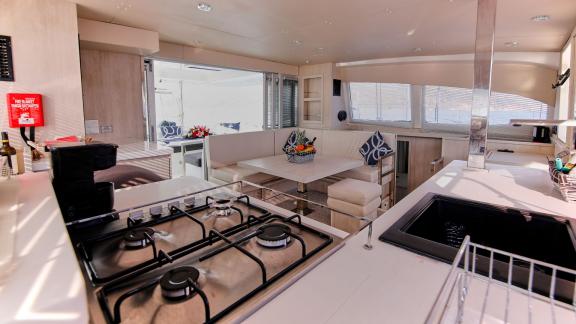 The galley and dining area on catamaran Derya feature modern equipment and a cozy dining nook.