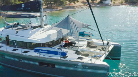 Enjoy the relaxed life aboard the Catamaran Lucky Clover anchored in a tranquil bay.