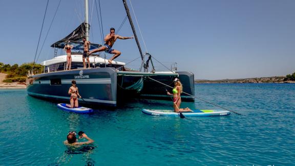 Paddleboard ve berrak suya atlamalarla dolu macera dolu Lucky Clover Katamaranında eğlence.