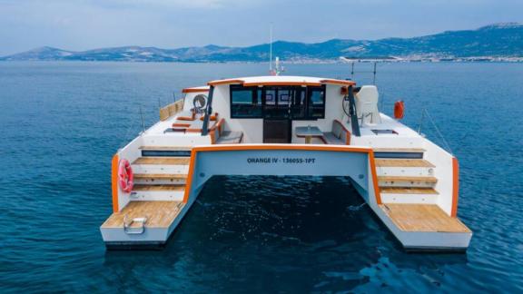 В Сплите катамаран Orange с деревянными ступенями, диванами и входом в салон.