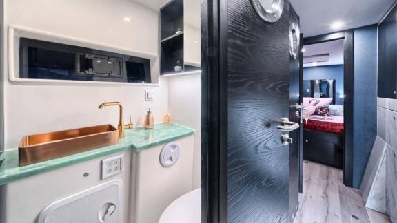 Luna 49 Red banyosu yeşil tezgah, bakır lavabo ve dekoratif detaylarla kabinden doğrudan erişim sunuyor.