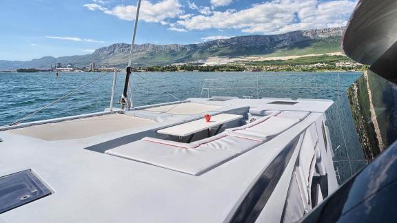 The Luna 49 Red catamaran offers a front net and cushioned lounge area while anchored near Split.