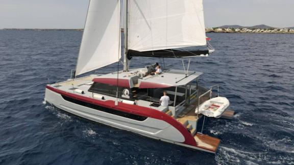 Luna 49 Red katamaran yelkenli halde ilerliyor, arka güvertesi ve bağlı botuyla Split kıyılarına yakın seyrediyor.
