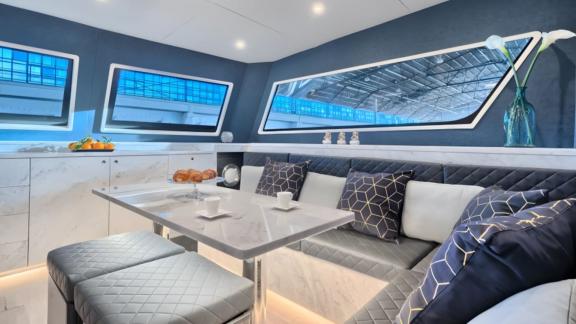 Luna 49 Red’in salonu geometrik yastıklar, mermer masa ve geniş camlarla şık ve aydınlık bir ortam sunuyor.