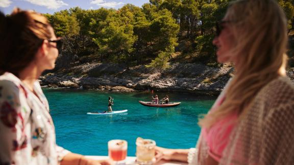 Watching stand-up paddling and kayaking from the comfort of the yacht.