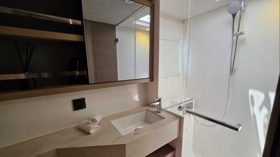 Zalina’s bathroom features clean lines and a glass shower for a bright atmosphere.